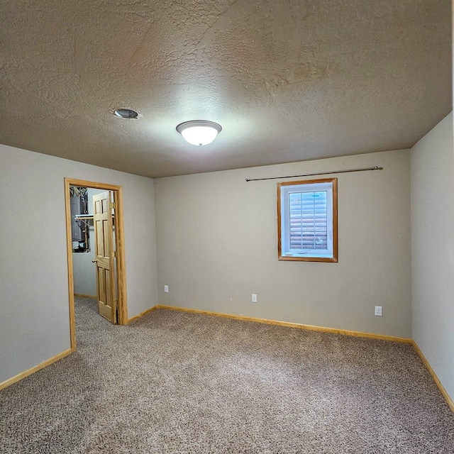 611 16th St, Minot, ND 58701 - carpeted spare room featuring baseboards and a textured ceiling