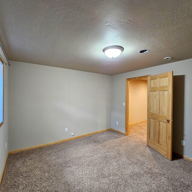 611 16th St, Minot, ND 58701 - carpeted spare room featuring baseboards and a textured ceiling