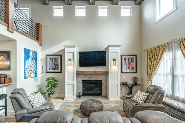 615 2nd St, Garrison, ND 58540 - living room with a towering ceiling, light wood-style floors, a tile fireplace, beamed ceiling, and baseboards