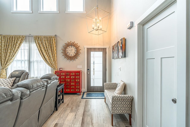 615 2nd St, Garrison, ND 58540 - entryway with light wood-style floors, a chandelier, a towering ceiling, and baseboards