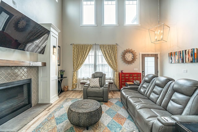 615 2nd St, Garrison, ND 58540 - living room with a high ceiling, wood finished floors, a tile fireplace, healthy amount of natural light, and a chandelier