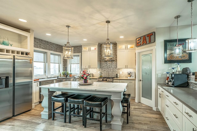 615 2nd St, Garrison, ND 58540 - kitchen with appliances with stainless steel finishes, premium range hood, a sink, light wood-style flooring, and recessed lighting