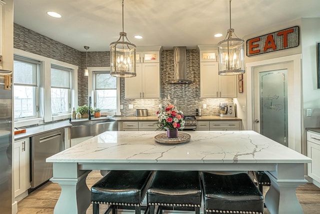 615 2nd St, Garrison, ND 58540 - kitchen with wall chimney range hood, a chandelier, stainless steel appliances, a sink, and recessed lighting