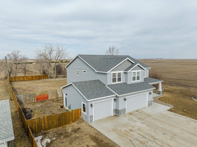 615 2nd St, Garrison, ND 58540 - view of side of property featuring roof with shingles, driveway, an attached garage, and stone siding