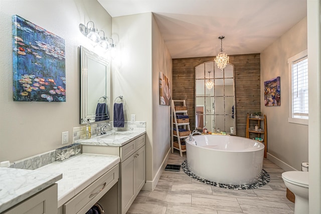 615 2nd St, Garrison, ND 58540 - full bath featuring a freestanding bath, a chandelier, toilet, baseboards, and vanity