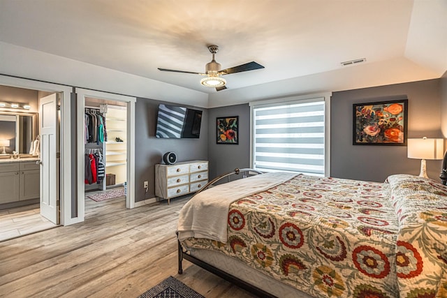 615 2nd St, Garrison, ND 58540 - bedroom with light wood-style floors, a walk in closet, ceiling fan, ensuite bath, and a closet