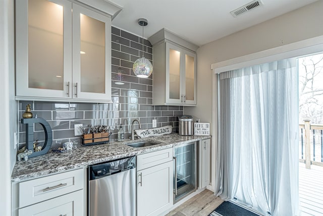 615 2nd St, Garrison, ND 58540 - kitchen with dishwasher, a sink, light stone counters, tasteful backsplash, and glass insert cabinets