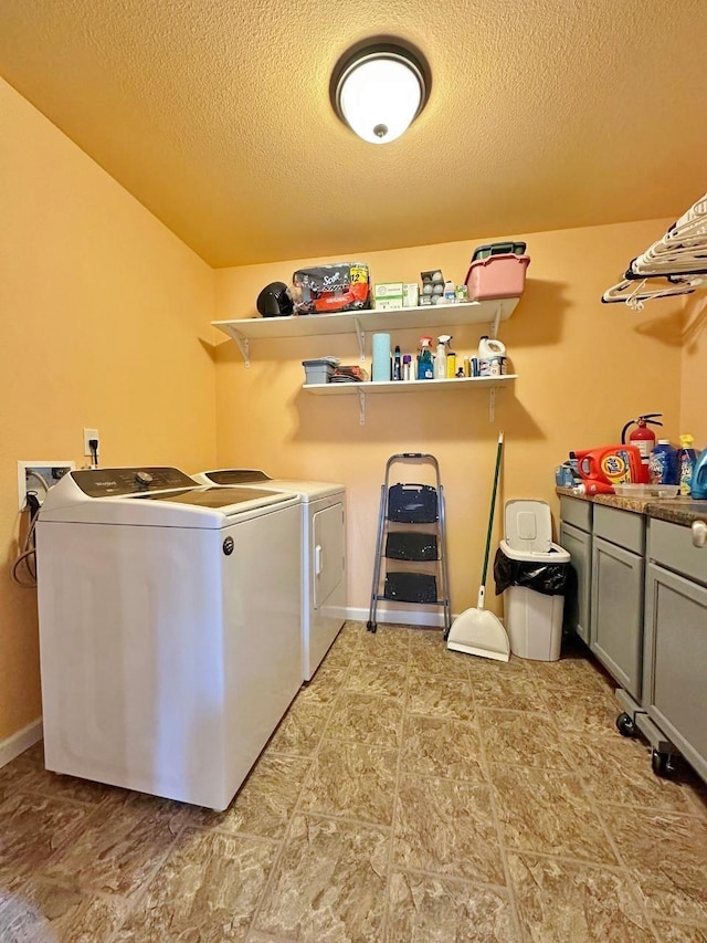 1312 28th St, Minot, ND 58703 - washroom featuring washer and clothes dryer, cabinet space, and a textured ceiling