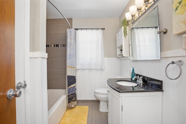 1001 20th St, Minot, ND 58703 - bathroom with wainscoting, toilet, vanity, and shower / tub combo with curtain