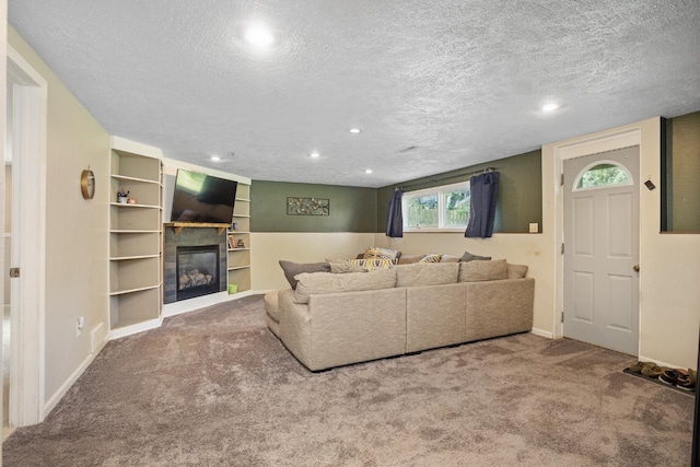 1001 20th St, Minot, ND 58703 - living room featuring a textured ceiling, carpet, a glass covered fireplace, baseboards, and recessed lighting