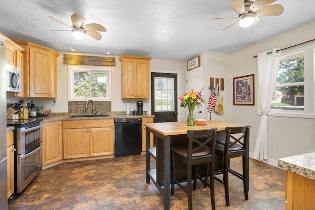 1001 20th St, Minot, ND 58703 - kitchen featuring appliances with stainless steel finishes, a sink, ceiling fan, light brown cabinets, and a textured ceiling