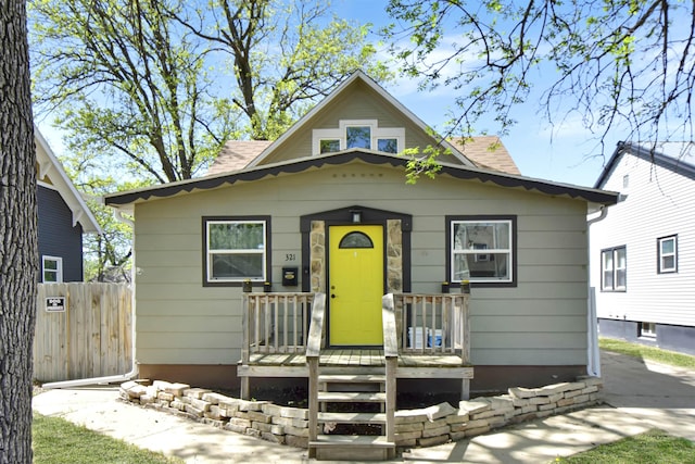 321 6th St, Minot, ND 58703 - bungalow-style home with covered porch and fence