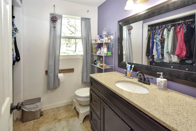 321 6th St, Minot, ND 58703 - bathroom with tile patterned floors, vanity, baseboards, and toilet