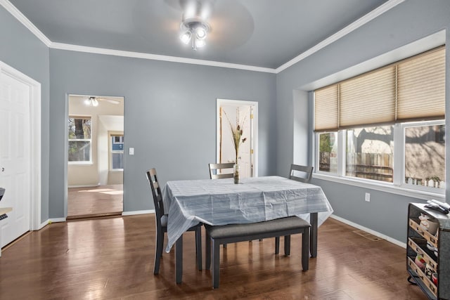 706 E Central Ave, Minot, ND 58701 - dining space featuring a ceiling fan, plenty of natural light, crown molding, and dark wood-style floors