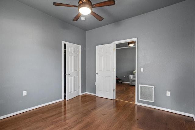 706 E Central Ave, Minot, ND 58701 - unfurnished bedroom featuring wood finished floors, baseboards, and ceiling fan