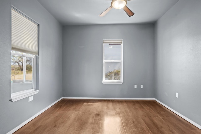 706 E Central Ave, Minot, ND 58701 - unfurnished room with wood finished floors, a ceiling fan, and baseboards