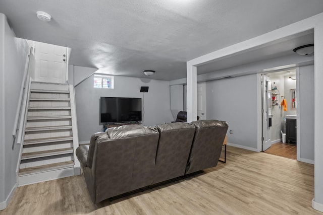706 E Central Ave, Minot, ND 58701 - living area featuring light wood-type flooring, stairs, baseboards, and a textured ceiling