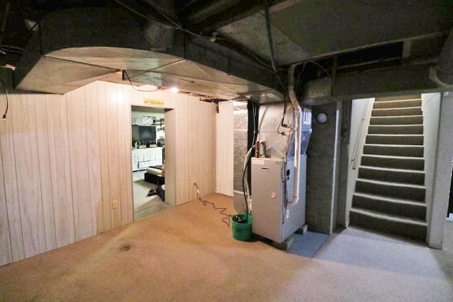 306 Davis St, Burlington, ND 58722 - below grade area with heating unit, wooden walls, stairs, and carpet