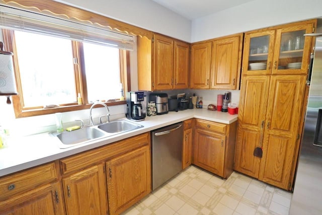 306 Davis St, Burlington, ND 58722 - kitchen featuring dishwasher, a sink, brown cabinets, light countertops, and light floors