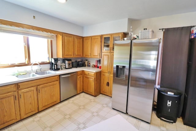 306 Davis St, Burlington, ND 58722 - kitchen with appliances with stainless steel finishes, a sink, light countertops, light flooring, and brown cabinets