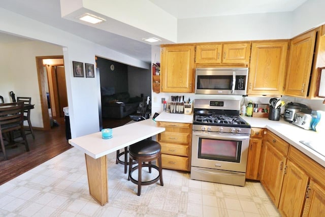 306 Davis St, Burlington, ND 58722 - kitchen with stainless steel appliances, light floors, light countertops, and a kitchen bar