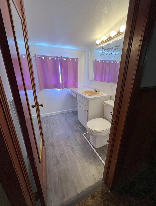 909 NW 10th Ave, Minot, ND 58703 - bathroom featuring wood finished floors, vanity, and toilet
