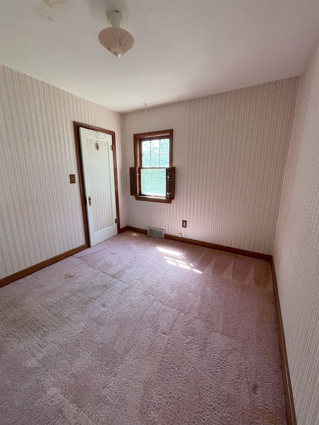 909 NW 10th Ave, Minot, ND 58703 - spare room featuring wallpapered walls and carpet flooring