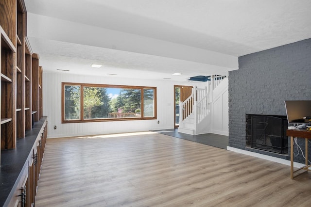4401 38th St, Minot, ND 58701 - unfurnished living room with wood finished floors, a fireplace, and stairway
