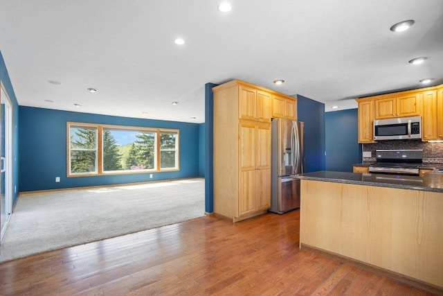 4401 38th St, Minot, ND 58701 - kitchen featuring appliances with stainless steel finishes, open floor plan, light wood-style flooring, recessed lighting, and tasteful backsplash