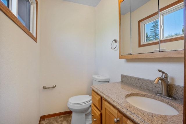 4401 38th St, Minot, ND 58701 - bathroom featuring toilet, vanity, and baseboards