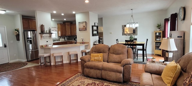 1728 Rivers Edge, Minot, ND 58701 - living area featuring dark wood-style flooring, recessed lighting, baseboards, and a chandelier