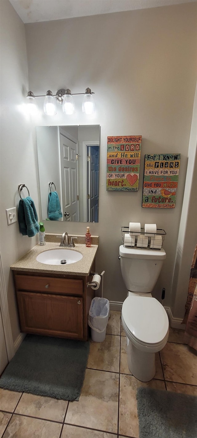 1728 Rivers Edge, Minot, ND 58701 - bathroom with vanity, toilet, baseboards, and tile patterned flooring
