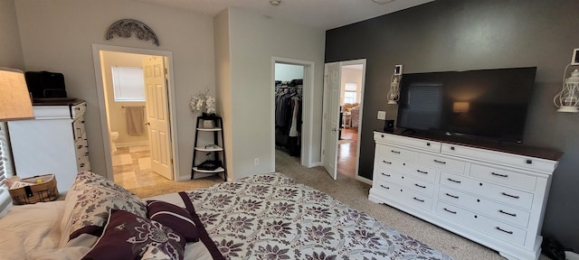 1728 Rivers Edge, Minot, ND 58701 - bedroom featuring a walk in closet, ensuite bathroom, a closet, and light carpet