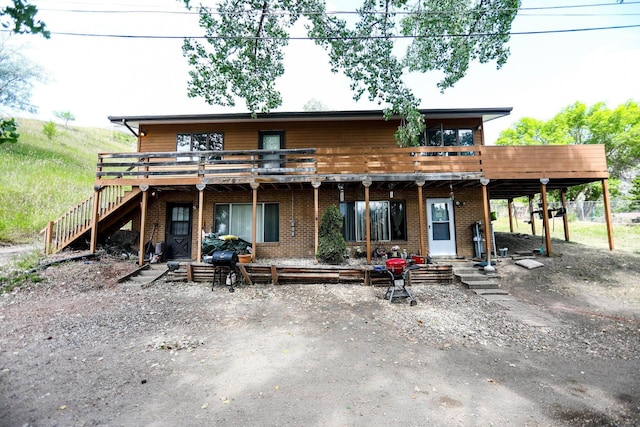 916 12th Ave, Minot, ND 58703 - view of front of home featuring a wooden deck, brick siding, and stairway