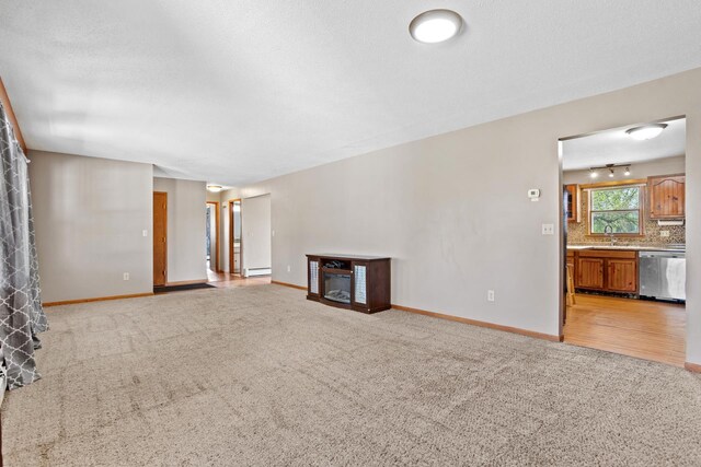3574 91st St, Mohall, ND 58761 - unfurnished living room with light carpet, baseboards, and a sink
