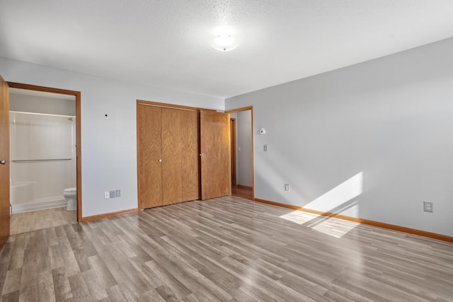 3574 91st St, Mohall, ND 58761 - unfurnished bedroom with light wood-type flooring, baseboards, a closet, and ensuite bathroom