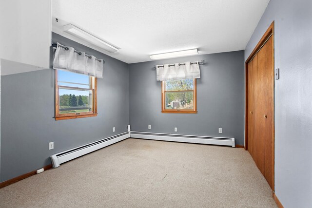3574 91st St, Mohall, ND 58761 - carpeted spare room with healthy amount of natural light, baseboard heating, and baseboards