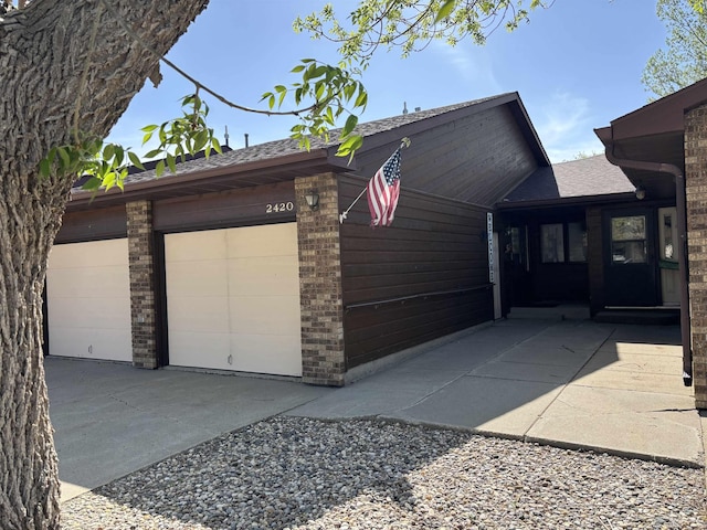 2420 8th St Unit 2420, Minot, ND 58703 - view of property exterior featuring a shingled roof and brick siding