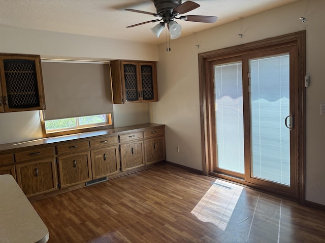 2420 8th St Unit 2420, Minot, ND 58703 - kitchen featuring dark wood-style flooring, a ceiling fan, and baseboards