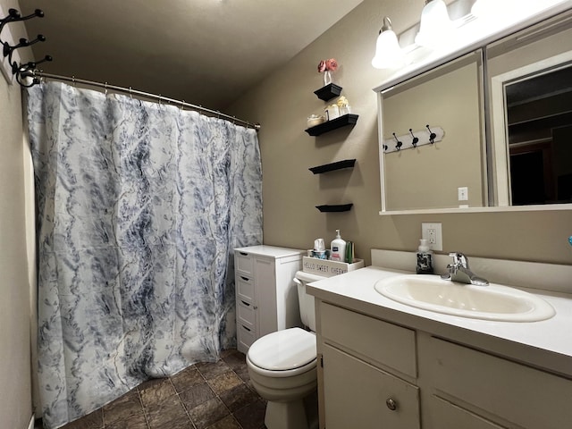 410 6th Ave, Minot, ND 58703 - full bathroom featuring vanity, toilet, stone finish floors, and curtained shower