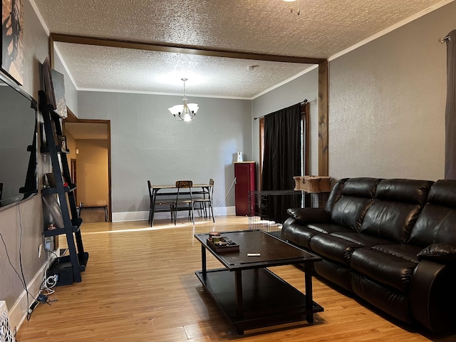 410 6th Ave, Minot, ND 58703 - living room featuring a chandelier, wood finished floors, a textured ceiling, and ornamental molding