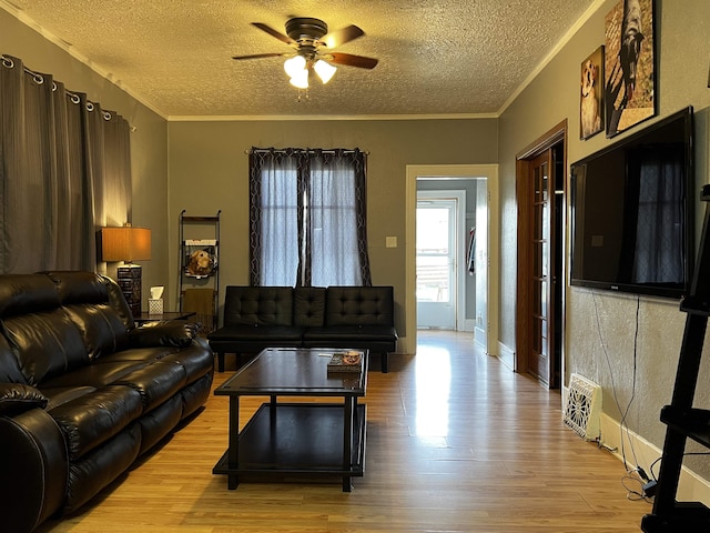 410 6th Ave, Minot, ND 58703 - living room featuring a textured ceiling, a ceiling fan, light wood-style floors, and crown molding