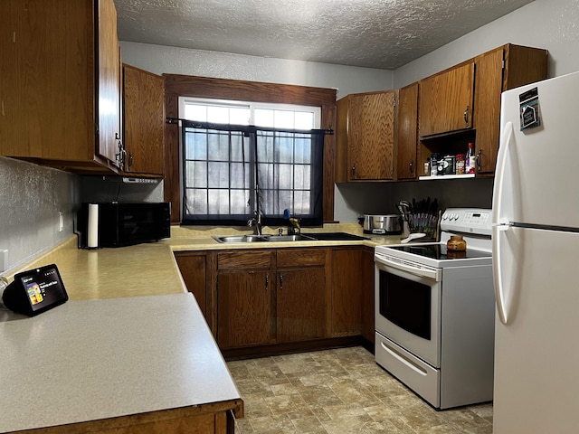 410 6th Ave, Minot, ND 58703 - kitchen featuring white appliances, light countertops, a sink, and a textured ceiling