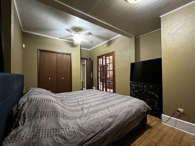 410 6th Ave, Minot, ND 58703 - bedroom with wood finished floors, ornamental molding, a textured wall, baseboards, and a closet