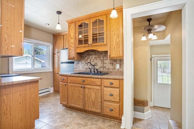 1309 1st St, Minot, ND 58701 - kitchen with a sink, a baseboard radiator, backsplash, and hanging light fixtures