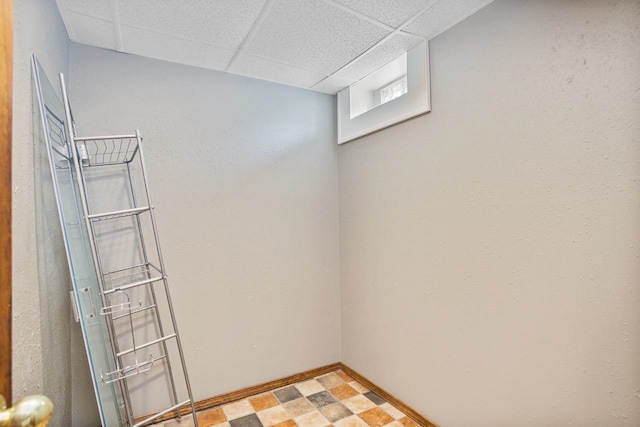 1309 1st St, Minot, ND 58701 - below grade area with a paneled ceiling, baseboards, and light floors