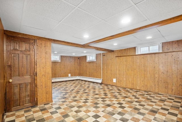 1309 1st St, Minot, ND 58701 - basement with tile patterned floors, a baseboard heating unit, wood walls, healthy amount of natural light, and recessed lighting