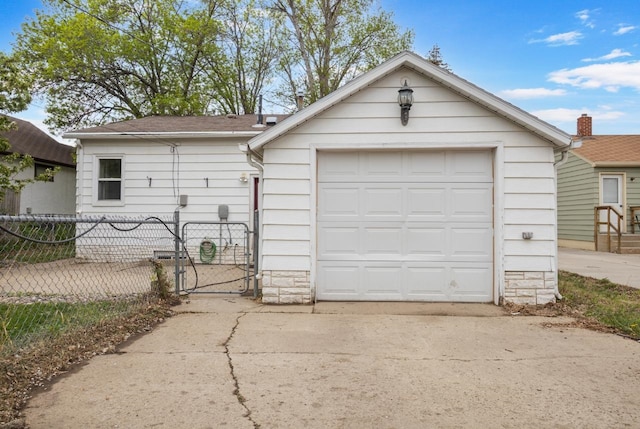 1309 1st St, Minot, ND 58701 - garage featuring fence, concrete driveway, and a gate