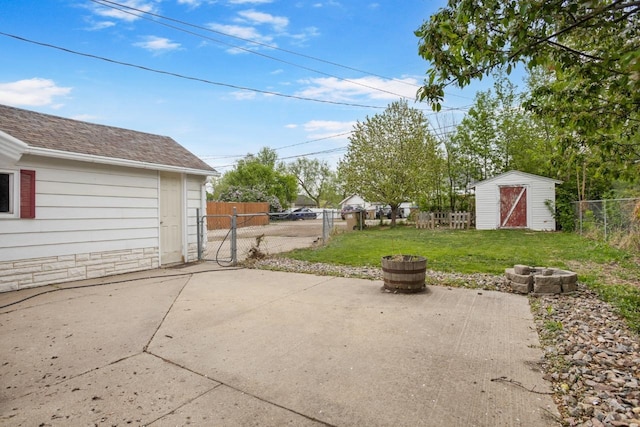 1309 1st St, Minot, ND 58701 - view of patio featuring an outdoor fire pit, a shed, and an outbuilding