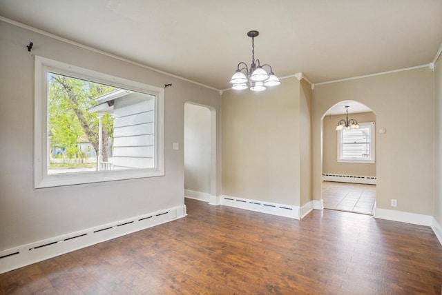1309 1st St, Minot, ND 58701 - empty room featuring arched walkways, a chandelier, a baseboard radiator, and crown molding